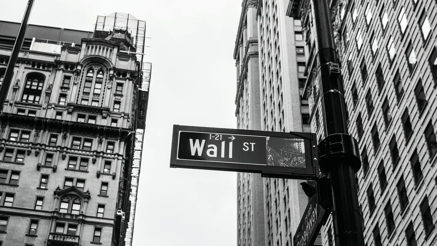 The Wall Street street sign between old high-rises in Manhattan, in black and white.